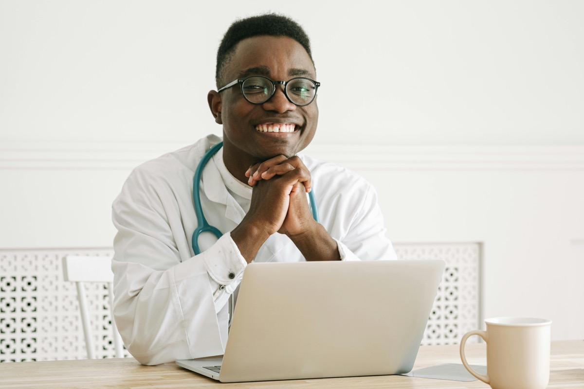Smiling clinician working at a laptop